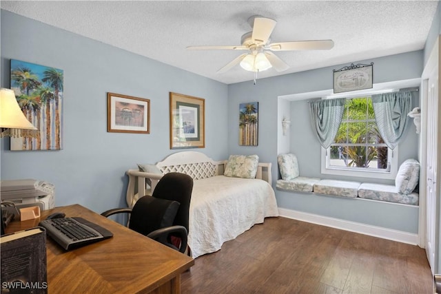 3500 Liberty St, Port Charlotte, FL 33948 - bedroom with an office area, a textured ceiling, dark wood finished floors, baseboards, and ceiling fan