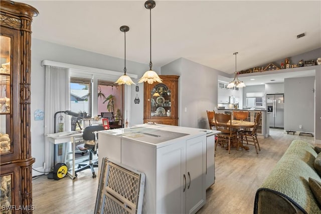 923 SW 4th Pl, Cape Coral, FL 33991 - kitchen with stainless steel fridge, light wood-style flooring, vaulted ceiling, a center island, and hanging light fixtures