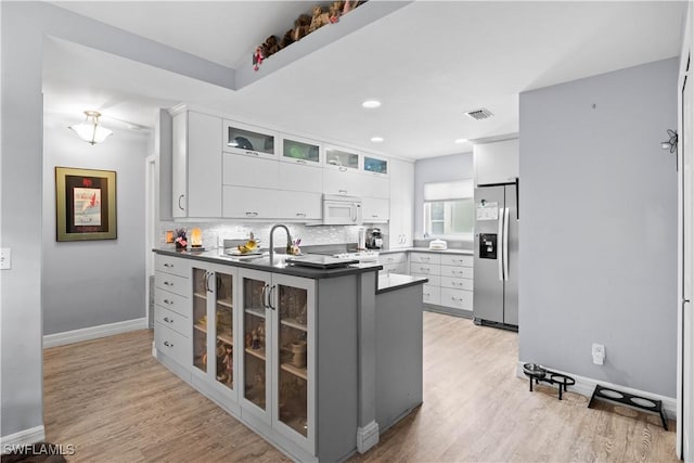 923 SW 4th Pl, Cape Coral, FL 33991 - kitchen featuring stainless steel fridge with ice dispenser, white microwave, a peninsula, light wood-style floors, and recessed lighting