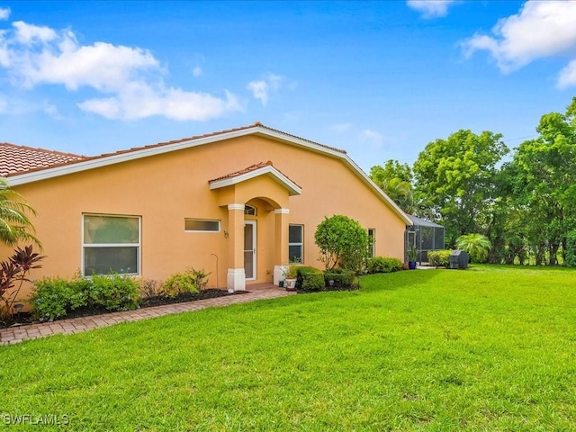 15137 Cortona Way, Naples, FL 34120 - view of front of house with a front yard, stucco siding, and a lanai