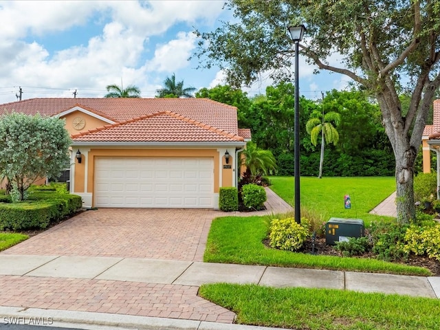 15137 Cortona Way, Naples, FL 34120 - mediterranean / spanish home with a front yard, a tiled roof, decorative driveway, stucco siding, and a garage