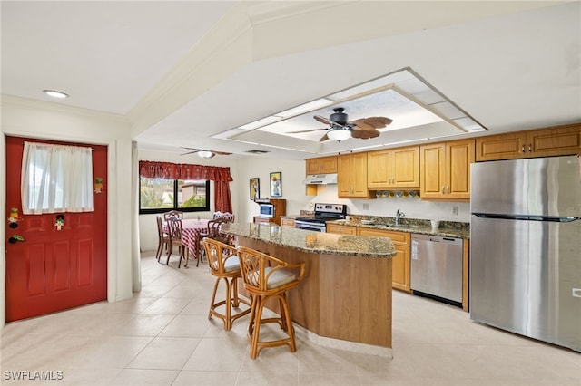 27771 Hacienda E Blvd Unit 223A, Bonita Springs, FL 34135 - kitchen featuring appliances with stainless steel finishes, a sink, a center island, stone countertops, and light tile patterned floors