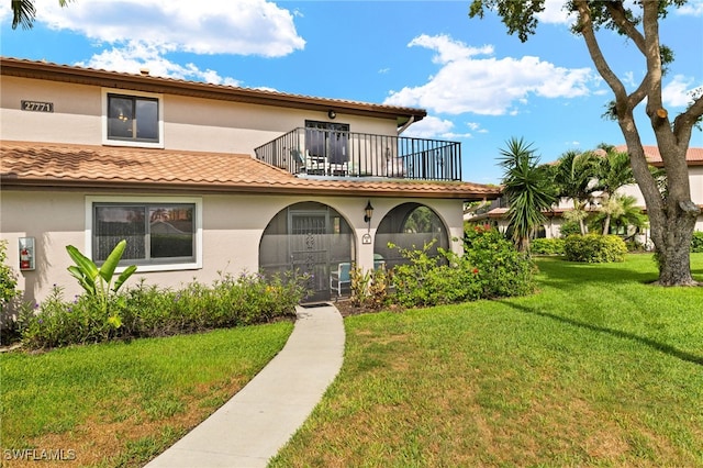 27771 Hacienda E Blvd Unit 223A, Bonita Springs, FL 34135 - view of front of property with a balcony, stucco siding, a front yard, and a tile roof
