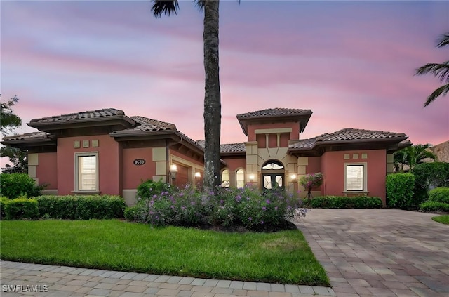 6528 Costa Cir, Naples, FL 34113 - view of front of house with a garage, a tile roof, stucco siding, and a yard