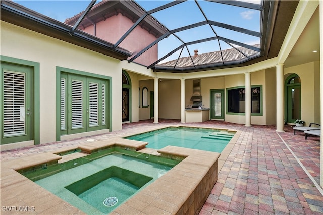 6528 Costa Cir, Naples, FL 34113 - view of swimming pool featuring exterior kitchen, a patio, a lanai, and a pool with connected hot tub