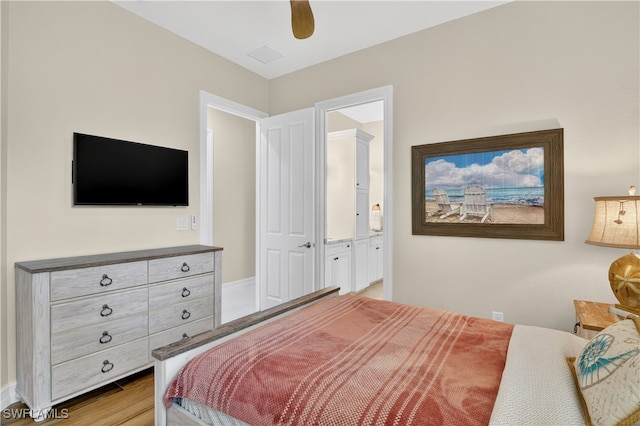 6528 Costa Cir, Naples, FL 34113 - bedroom with connected bathroom, wood finished floors, and ceiling fan