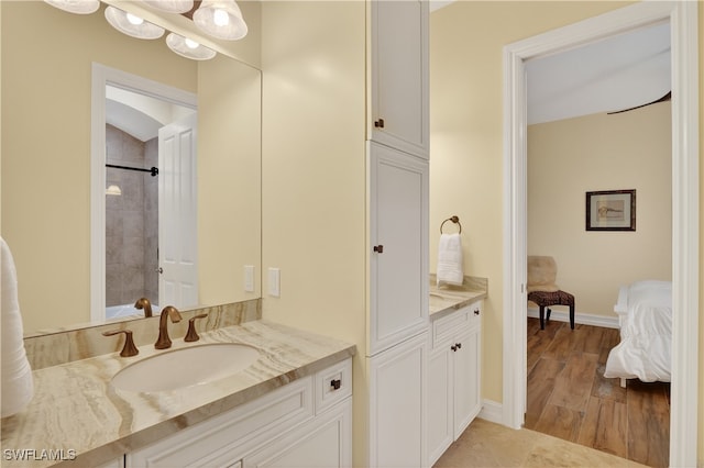 6528 Costa Cir, Naples, FL 34113 - bathroom featuring vanity, ensuite bathroom, baseboards, and wood finished floors