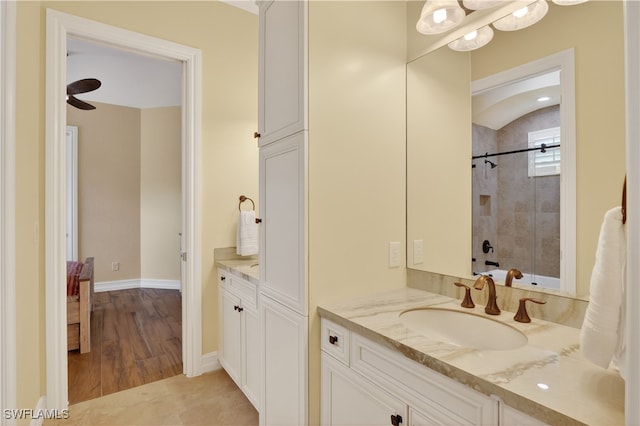 6528 Costa Cir, Naples, FL 34113 - bathroom with vanity, a tile shower, baseboards, and wood finished floors