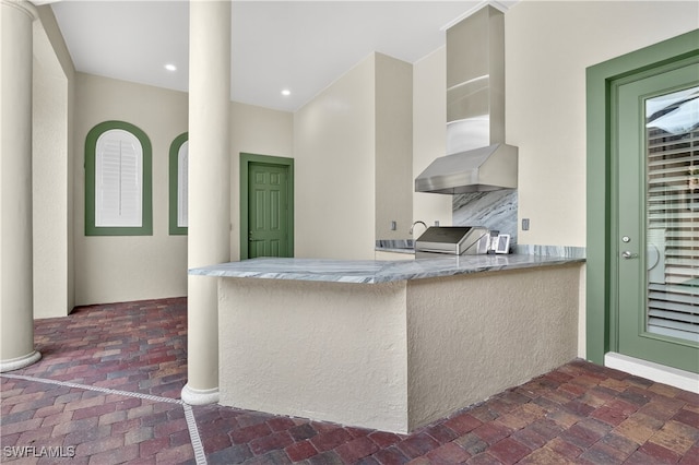 6528 Costa Cir, Naples, FL 34113 - kitchen featuring wall chimney exhaust hood and a peninsula
