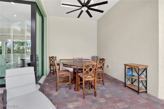 6528 Costa Cir, Naples, FL 34113 - dining space with a ceiling fan, a textured wall, and brick patterned floors