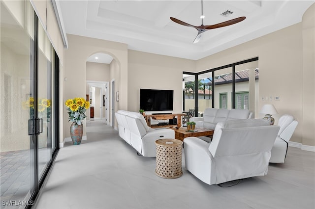 6528 Costa Cir, Naples, FL 34113 - living room featuring a ceiling fan, arched walkways, a raised ceiling, coffered ceiling, and baseboards