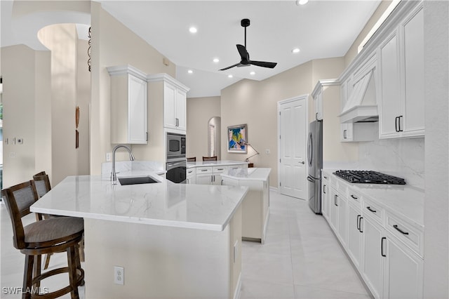 6528 Costa Cir, Naples, FL 34113 - kitchen featuring a sink, ceiling fan, stainless steel appliances, a peninsula, and arched walkways