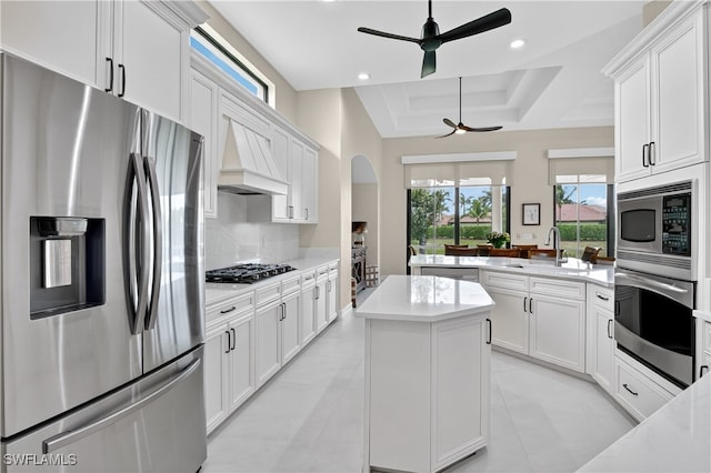 6528 Costa Cir, Naples, FL 34113 - kitchen with appliances with stainless steel finishes, ceiling fan, a center island, a tray ceiling, and a peninsula