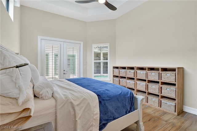 6528 Costa Cir, Naples, FL 34113 - bedroom with wood finished floors, baseboards, french doors, a raised ceiling, and access to exterior
