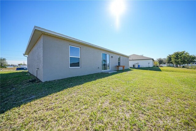 3002 NW 3rd Pl, Cape Coral, FL 33993 - back of property with stucco siding and a yard