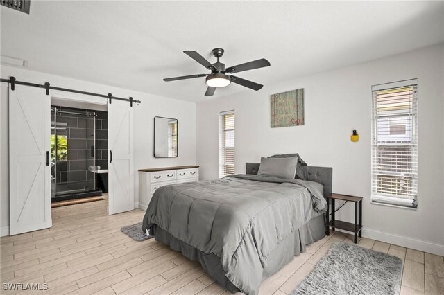 2001 Bahama Ave, Fort Myers, FL 33905 - bedroom with a barn door, light wood-style flooring, baseboards, and ceiling fan
