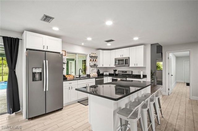 2001 Bahama Ave, Fort Myers, FL 33905 - kitchen with appliances with stainless steel finishes, a sink, light wood-style flooring, white cabinets, and recessed lighting