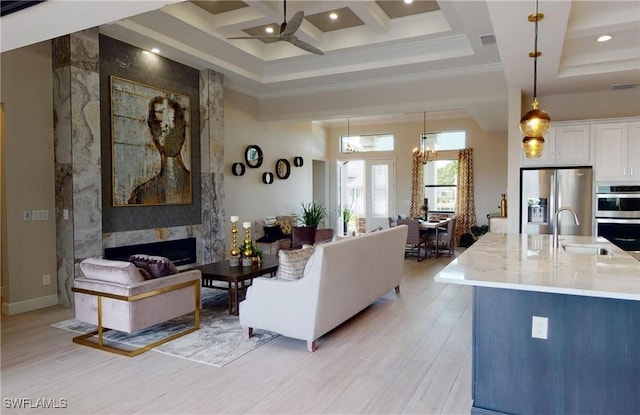 4426 Vasco St, Punta Gorda, FL 33950 - living room featuring a ceiling fan, a high ceiling, light wood-style flooring, a premium fireplace, and beamed ceiling