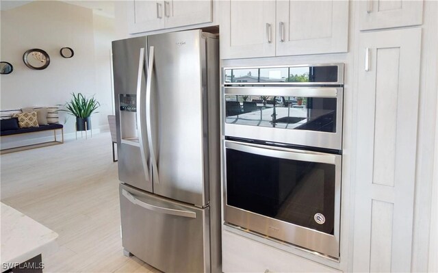 4426 Vasco St, Punta Gorda, FL 33950 - kitchen featuring stainless steel appliances, light wood-style floors, light stone countertops, and baseboards