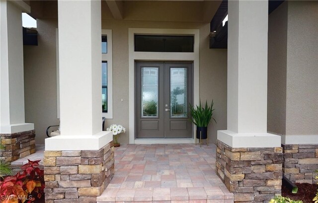 4426 Vasco St, Punta Gorda, FL 33950 - doorway to property with french doors, stucco siding, and stone siding