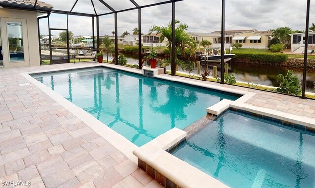 4426 Vasco St, Punta Gorda, FL 33950 - view of swimming pool with a pool with connected hot tub, a patio, a water view, glass enclosure, and a residential view