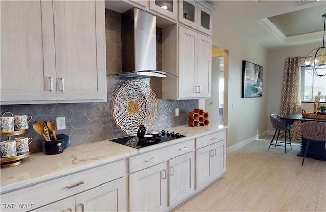 4426 Vasco St, Punta Gorda, FL 33950 - kitchen with wall chimney range hood, black electric stovetop, baseboards, light wood-style floors, and glass insert cabinets