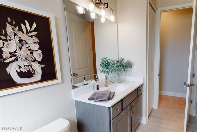 4426 Vasco St, Punta Gorda, FL 33950 - half bathroom with vanity, toilet, wood finished floors, and baseboards