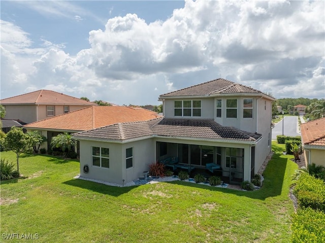 11164 Sparkleberry Dr, Fort Myers, FL 33913 - back of house featuring a tiled roof, stucco siding, a lawn, and a sunroom
