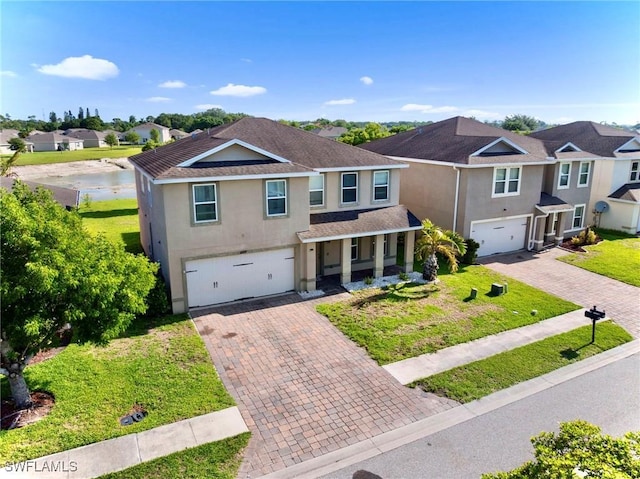 10329 Canal Brook Ln, Lehigh Acres, FL 33936 - view of front of home with stucco siding, decorative driveway, a garage, covered porch, and a residential view