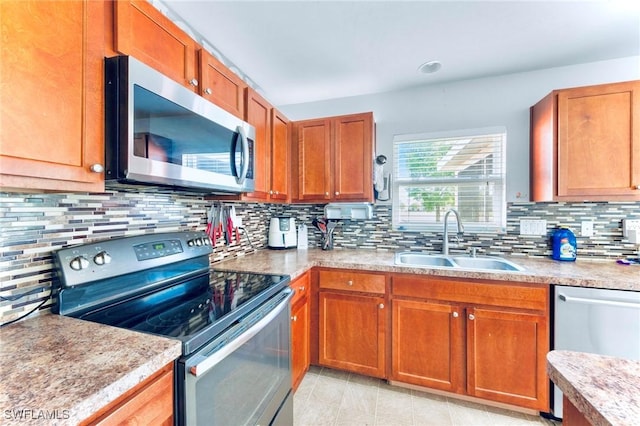 10329 Canal Brook Ln, Lehigh Acres, FL 33936 - kitchen featuring appliances with stainless steel finishes, a sink, backsplash, and brown cabinets