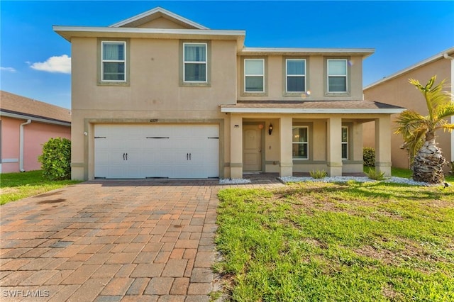 10329 Canal Brook Ln, Lehigh Acres, FL 33936 - view of front of home with stucco siding, decorative driveway, an attached garage, and a porch
