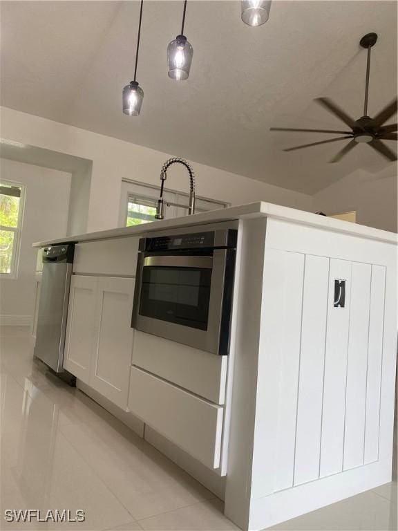 1640 8th St NE, Naples, FL 34120 - kitchen featuring appliances with stainless steel finishes, light tile patterned floors, a ceiling fan, white cabinetry, and pendant lighting