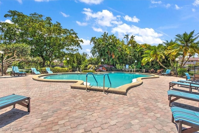 499 Forest Lakes Blvd Unit 306, Naples, FL 34105 - community pool with a patio area and view of wooded area