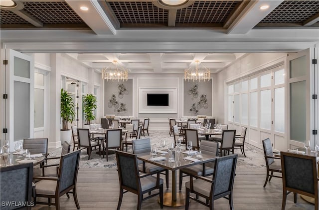 11220 Five Oaks Ln, Naples, FL 34120 - dining area featuring wood finished floors, a chandelier, coffered ceiling, beamed ceiling, and a decorative wall