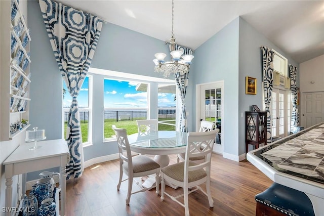 2250 SE 28th St, Cape Coral, FL 33904 - dining area featuring wood finished floors, a chandelier, high vaulted ceiling, and baseboards