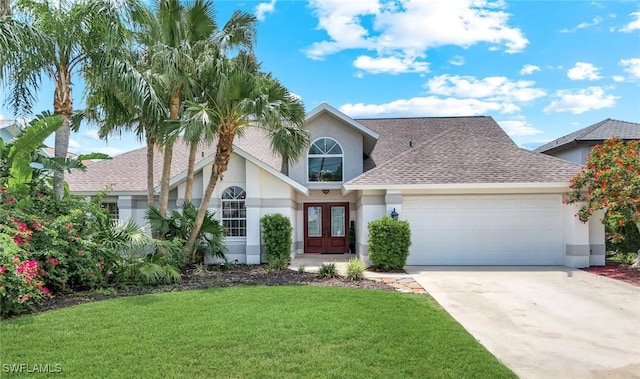 2250 SE 28th St, Cape Coral, FL 33904 - traditional-style house with french doors, stucco siding, an attached garage, a front yard, and driveway