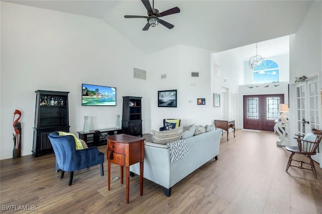 2250 SE 28th St, Cape Coral, FL 33904 - living room featuring high vaulted ceiling, wood finished floors, french doors, a ceiling fan, and a chandelier