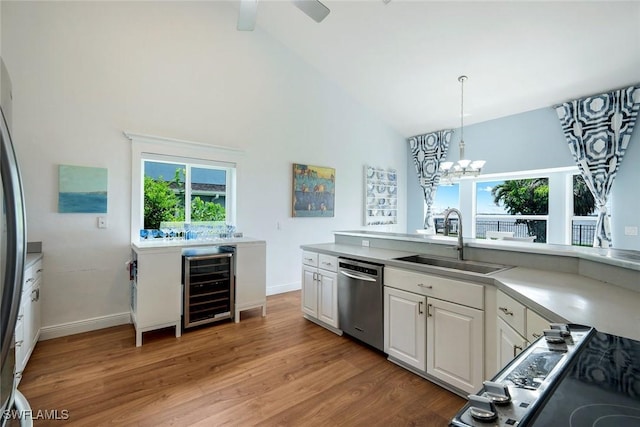 2250 SE 28th St, Cape Coral, FL 33904 - kitchen featuring appliances with stainless steel finishes, beverage cooler, a sink, white cabinetry, and light wood-style floors