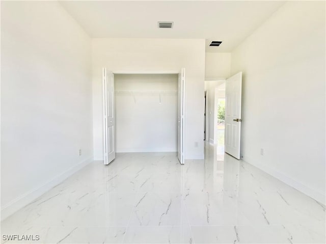 2710 21st St W, Lehigh Acres, FL 33971 - unfurnished bedroom with light marble finish floors, baseboards, and a closet