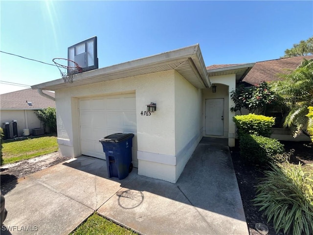 4767/4765 22nd St SW, Lehigh Acres, FL 33973 - view of property exterior with stucco siding, driveway, and central AC