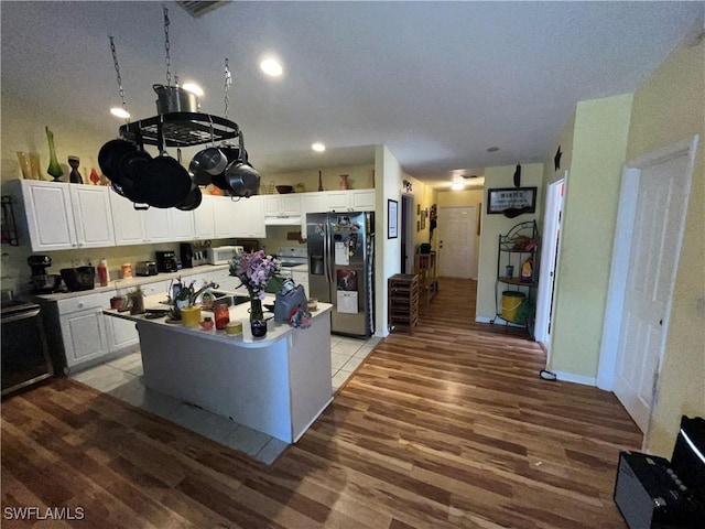 4767/4765 22nd St SW, Lehigh Acres, FL 33973 - kitchen with stainless steel refrigerator with ice dispenser, light wood finished floors, an island with sink, white cabinetry, and recessed lighting