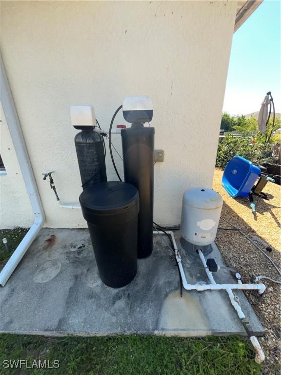 4767/4765 22nd St SW, Lehigh Acres, FL 33973 - exterior view of stucco siding and a water softener