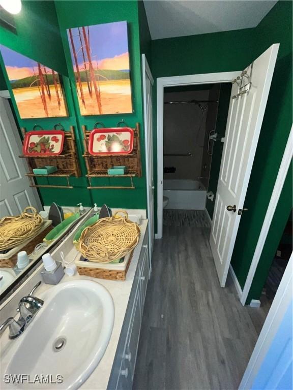 4767/4765 22nd St SW, Lehigh Acres, FL 33973 - full bath featuring wood finished floors, vanity, toilet, and washtub / shower combination