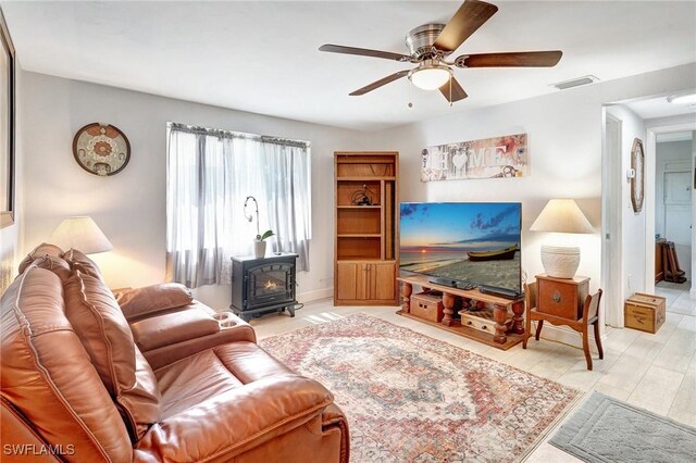 2153 Twin Brooks Rd, North Fort Myers, FL 33917 - living area featuring a wood stove and a ceiling fan