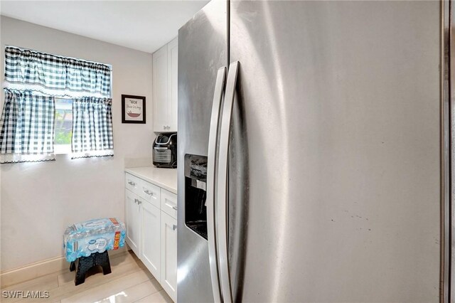 2153 Twin Brooks Rd, North Fort Myers, FL 33917 - kitchen with stainless steel fridge with ice dispenser, white cabinetry, and light countertops