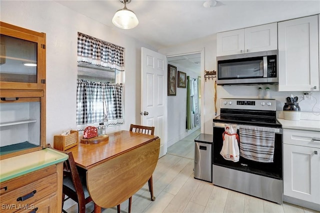 2153 Twin Brooks Rd, North Fort Myers, FL 33917 - kitchen with stainless steel appliances, white cabinets, light countertops, and light wood-style floors