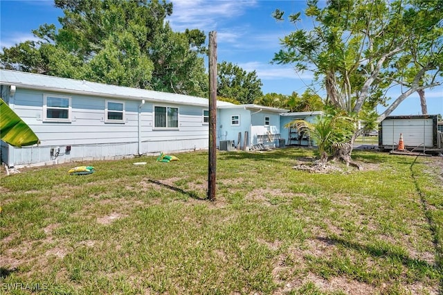 2153 Twin Brooks Rd, North Fort Myers, FL 33917 - rear view of house featuring central air condition unit and a yard