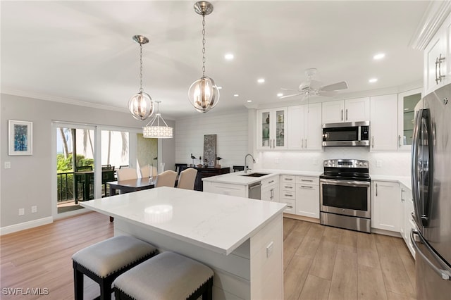 1080 S Collier Blvd Unit 103, Marco Island, FL 34145 - kitchen featuring appliances with stainless steel finishes, recessed lighting, a sink, a breakfast bar, and crown molding