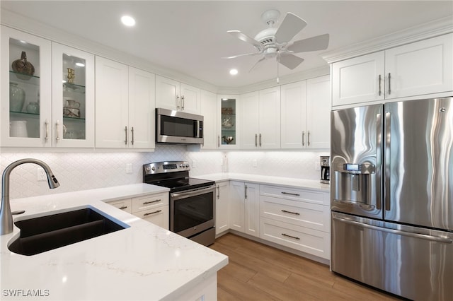 1080 S Collier Blvd Unit 103, Marco Island, FL 34145 - kitchen with stainless steel appliances, a sink, backsplash, white cabinetry, and recessed lighting