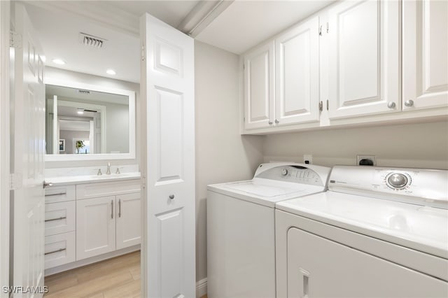 1080 S Collier Blvd Unit 103, Marco Island, FL 34145 - washroom featuring cabinet space, washer and clothes dryer, light wood finished floors, and recessed lighting